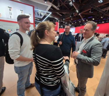 Schüler und Lehrerin im Gespräch mit Aussteller auf der Messe